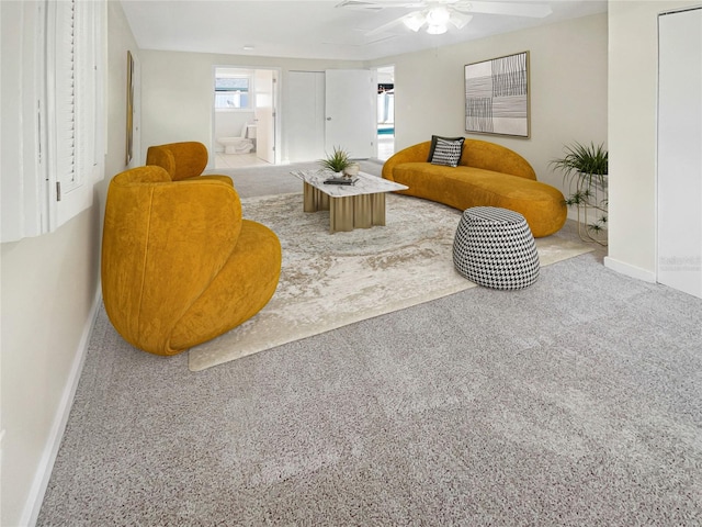 carpeted living room with ceiling fan