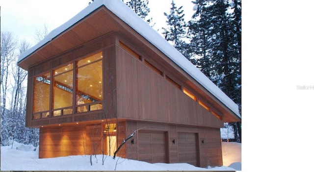 view of snowy exterior with a garage