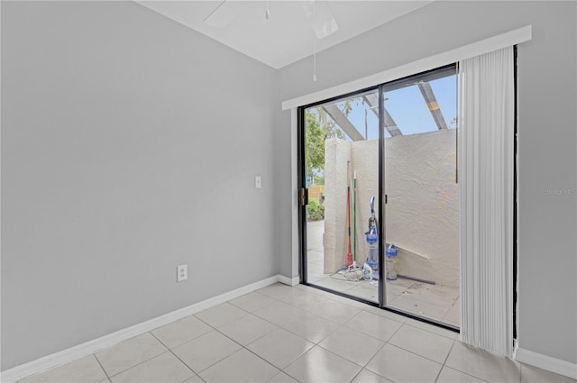 empty room with ceiling fan and light tile patterned floors