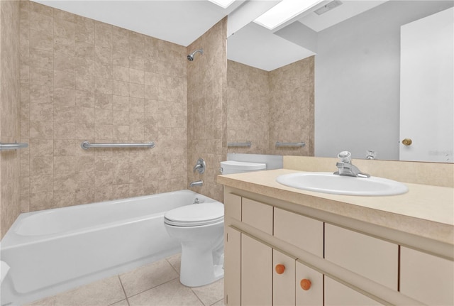 full bathroom with tile patterned flooring, tiled shower / bath, vanity, and toilet