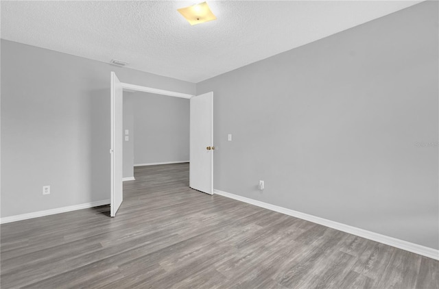 spare room with wood-type flooring and a textured ceiling