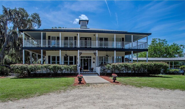 exterior space with a balcony, ceiling fan, a front lawn, and covered porch