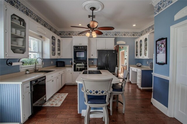 kitchen with black appliances, ceiling fan, crown molding, and dark wood-type flooring