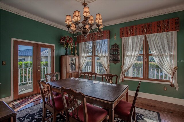 dining area with crown molding, a chandelier, french doors, and hardwood / wood-style flooring