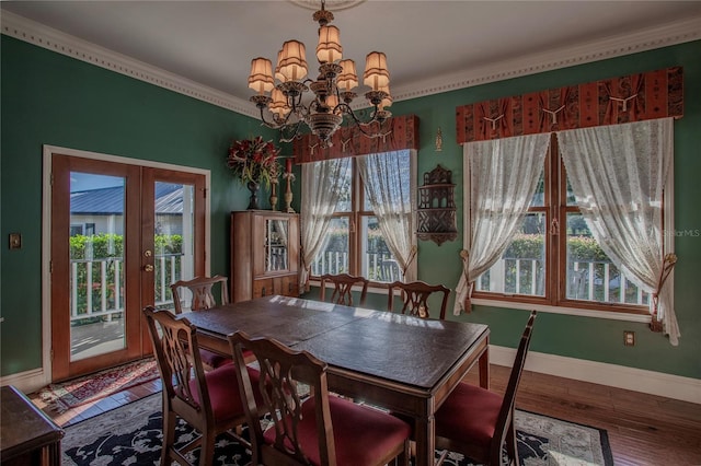 dining area featuring hardwood / wood-style flooring, a healthy amount of sunlight, french doors, and a notable chandelier