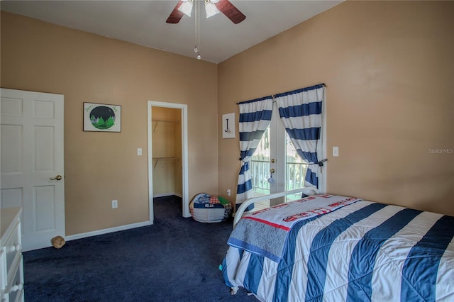 bedroom with dark colored carpet, a spacious closet, ceiling fan, and a closet