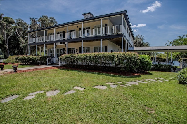 back of house featuring a yard and a balcony