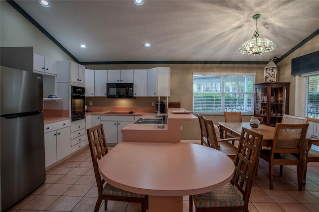 kitchen featuring white cabinetry, lofted ceiling, black appliances, and a notable chandelier