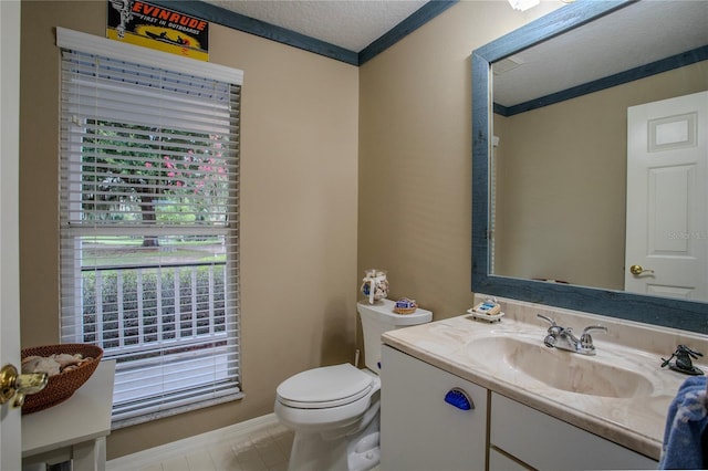 bathroom with ornamental molding, toilet, vanity, and a textured ceiling