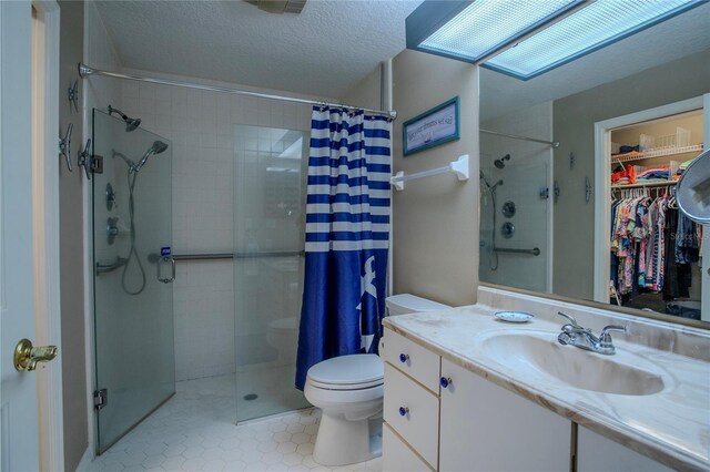 bathroom featuring a textured ceiling, toilet, vanity, tile patterned floors, and a shower with curtain