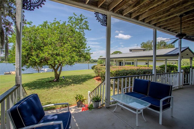 view of patio with a water view and ceiling fan