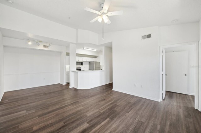 unfurnished living room featuring dark wood-type flooring and ceiling fan