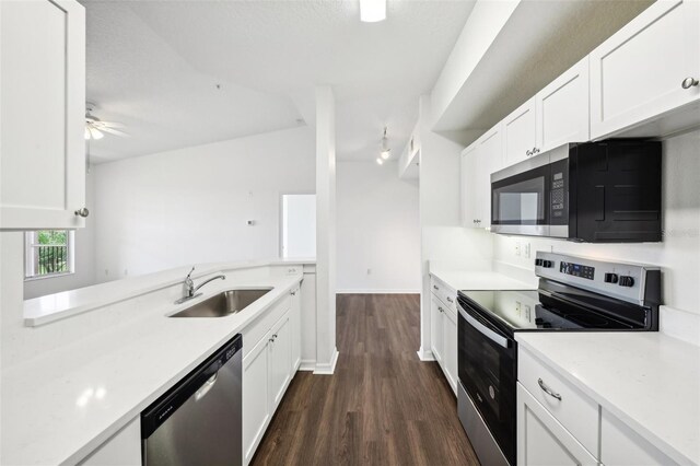 kitchen featuring ceiling fan, stainless steel appliances, white cabinets, sink, and dark wood-type flooring