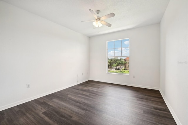 unfurnished room featuring baseboards, dark wood finished floors, and a ceiling fan