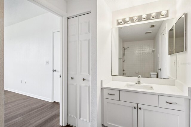 bathroom with toilet, hardwood / wood-style floors, and vanity