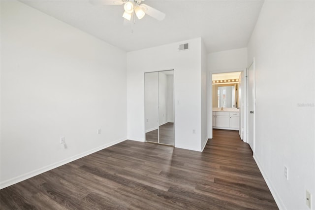 unfurnished bedroom featuring visible vents, baseboards, a closet, dark wood-style floors, and a ceiling fan