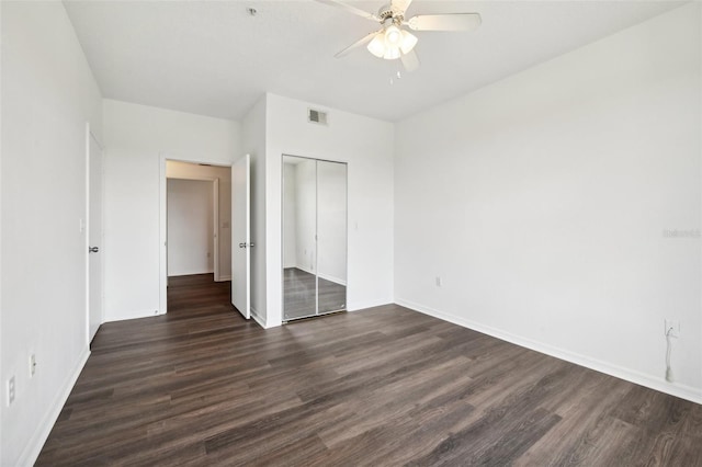 unfurnished bedroom featuring visible vents, a ceiling fan, dark wood finished floors, a closet, and baseboards