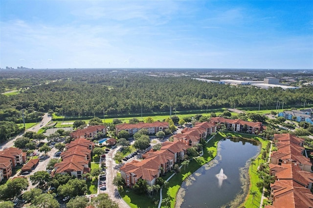 drone / aerial view with a forest view, a water view, and a residential view