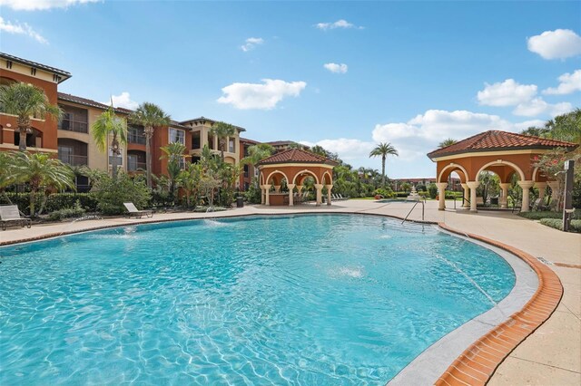 view of swimming pool featuring pool water feature, a gazebo, and a patio area