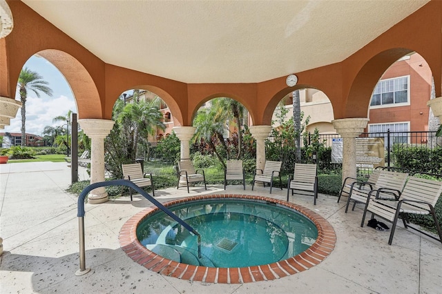 view of swimming pool featuring a hot tub and a patio area