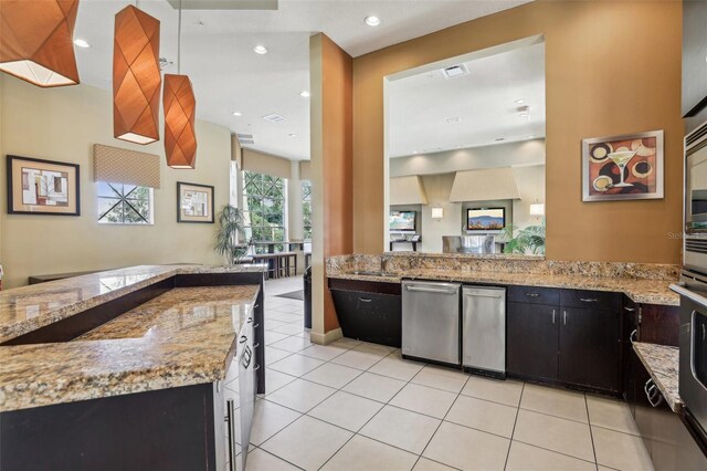 kitchen with stainless steel appliances, light stone countertops, sink, and light tile patterned floors