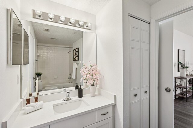 5536 Metrowest Blvd Unit 8-304, Orlando, FL 32811 - full bathroom featuring a closet, vanity, toilet, shower / bath combination, and a textured ceiling