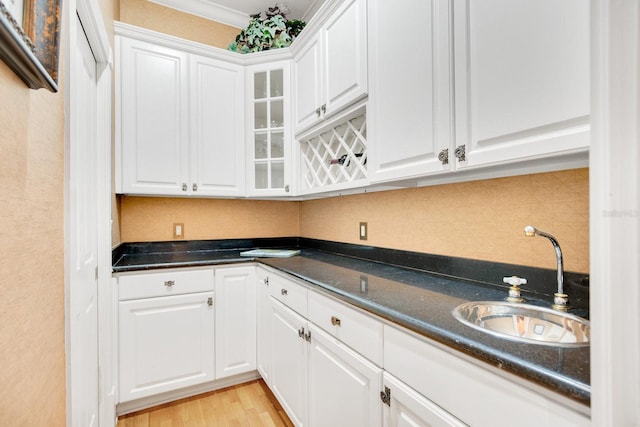 kitchen featuring white cabinetry, sink, decorative backsplash, and light wood-type flooring