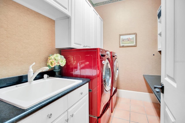 washroom featuring cabinets, sink, washer and dryer, and light tile patterned floors