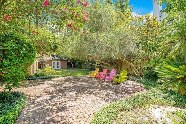 view of yard with an outbuilding, a patio, and french doors