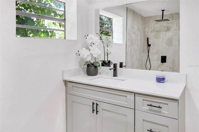 bathroom with vanity and tiled shower