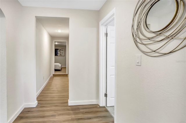 corridor with hardwood / wood-style flooring