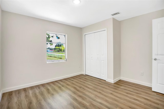 unfurnished bedroom featuring wood-type flooring and a closet