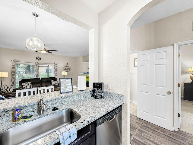 kitchen featuring sink, ceiling fan, light stone countertops, decorative light fixtures, and stainless steel dishwasher