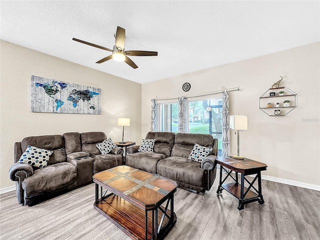 living room with ceiling fan, wood-type flooring, and a textured ceiling