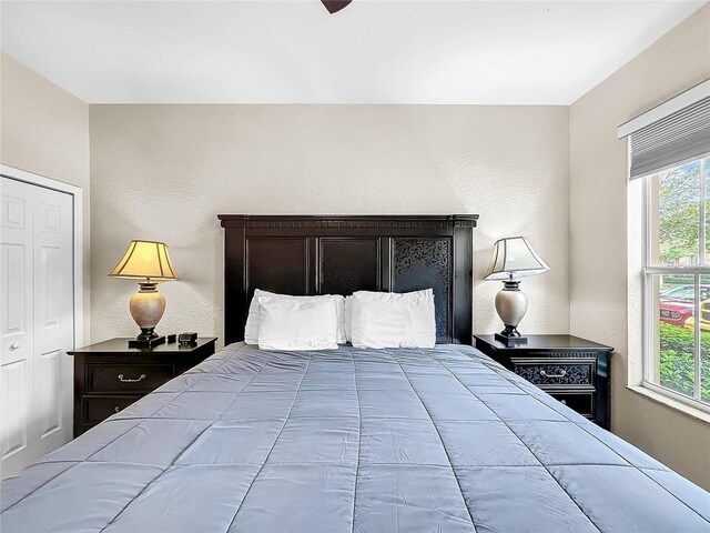 bedroom with multiple windows, a closet, and ceiling fan