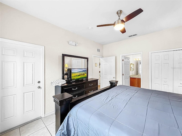 tiled bedroom with connected bathroom, ceiling fan, and a closet