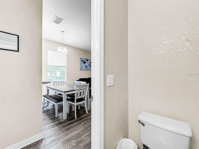 bathroom featuring hardwood / wood-style flooring, a textured ceiling, and toilet