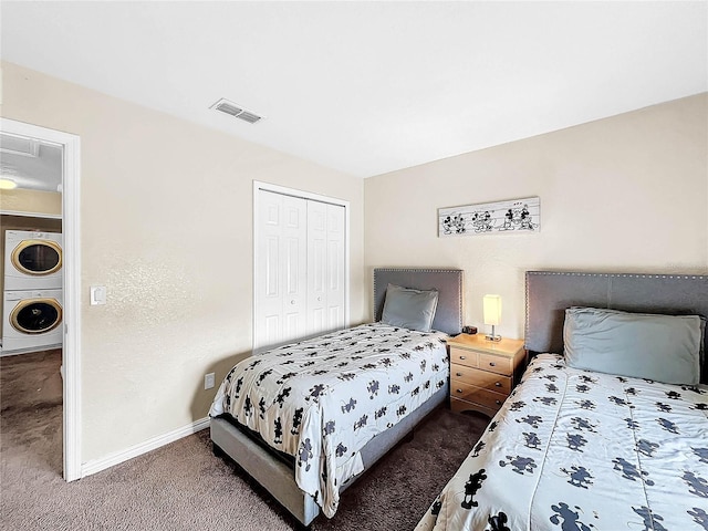 carpeted bedroom with a closet and stacked washing maching and dryer