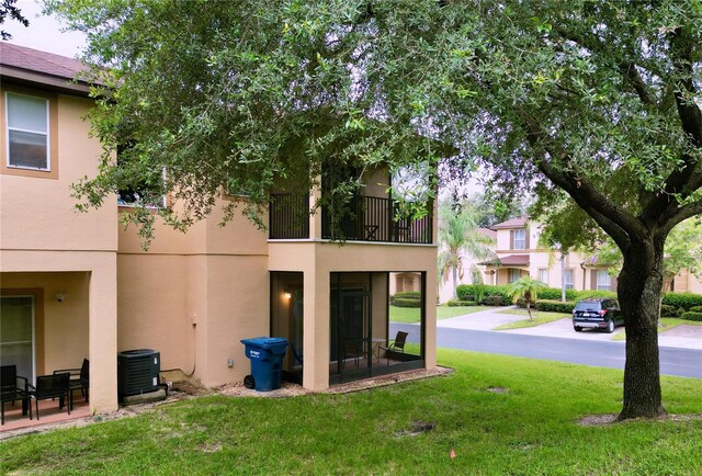 view of yard with a balcony and central AC unit