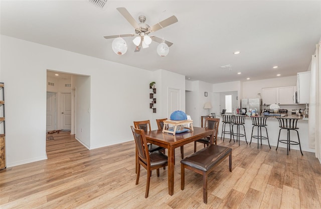 dining area with ceiling fan and light hardwood / wood-style floors