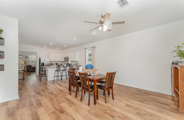 dining space featuring light wood-type flooring and ceiling fan