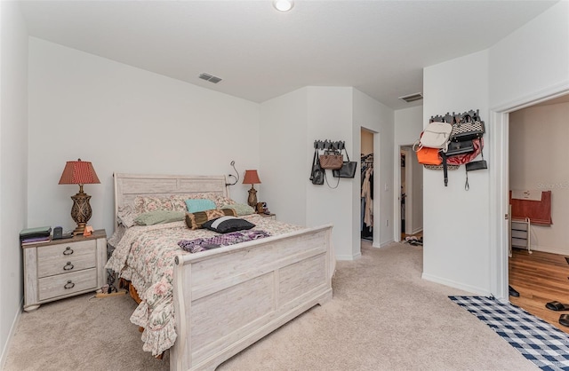 bedroom featuring a spacious closet, a closet, and light hardwood / wood-style floors