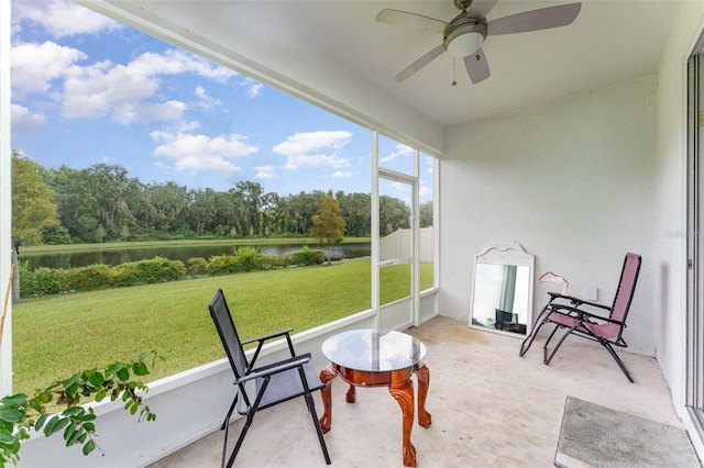 sunroom / solarium with a water view and ceiling fan