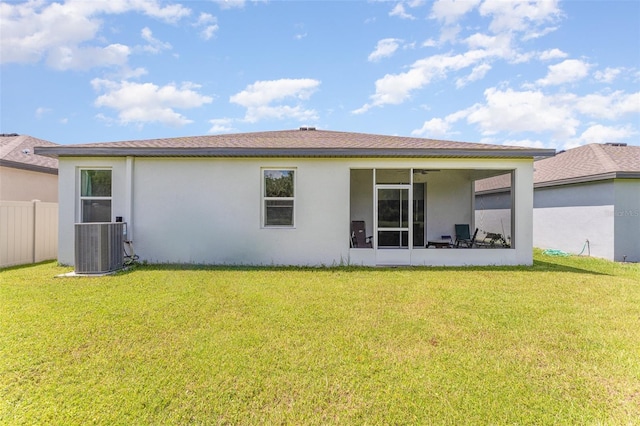 rear view of house featuring central AC unit and a yard