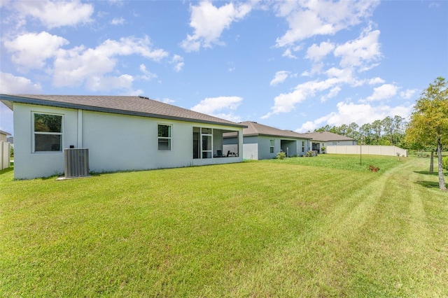 rear view of house with a yard and central AC unit