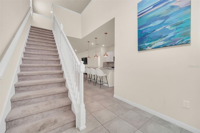 stairs with light tile patterned flooring and a towering ceiling