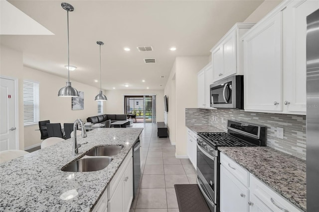 kitchen featuring white cabinetry, light tile patterned floors, stainless steel appliances, decorative backsplash, and sink