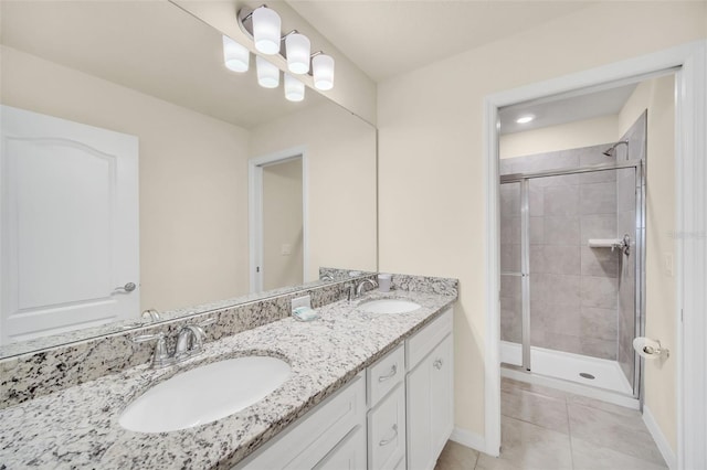 bathroom with a shower with door, double vanity, and tile patterned flooring