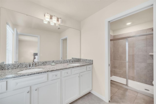 bathroom featuring tile patterned flooring, walk in shower, and double sink vanity