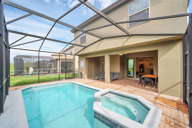 view of swimming pool with an in ground hot tub, a patio, a lawn, and a lanai